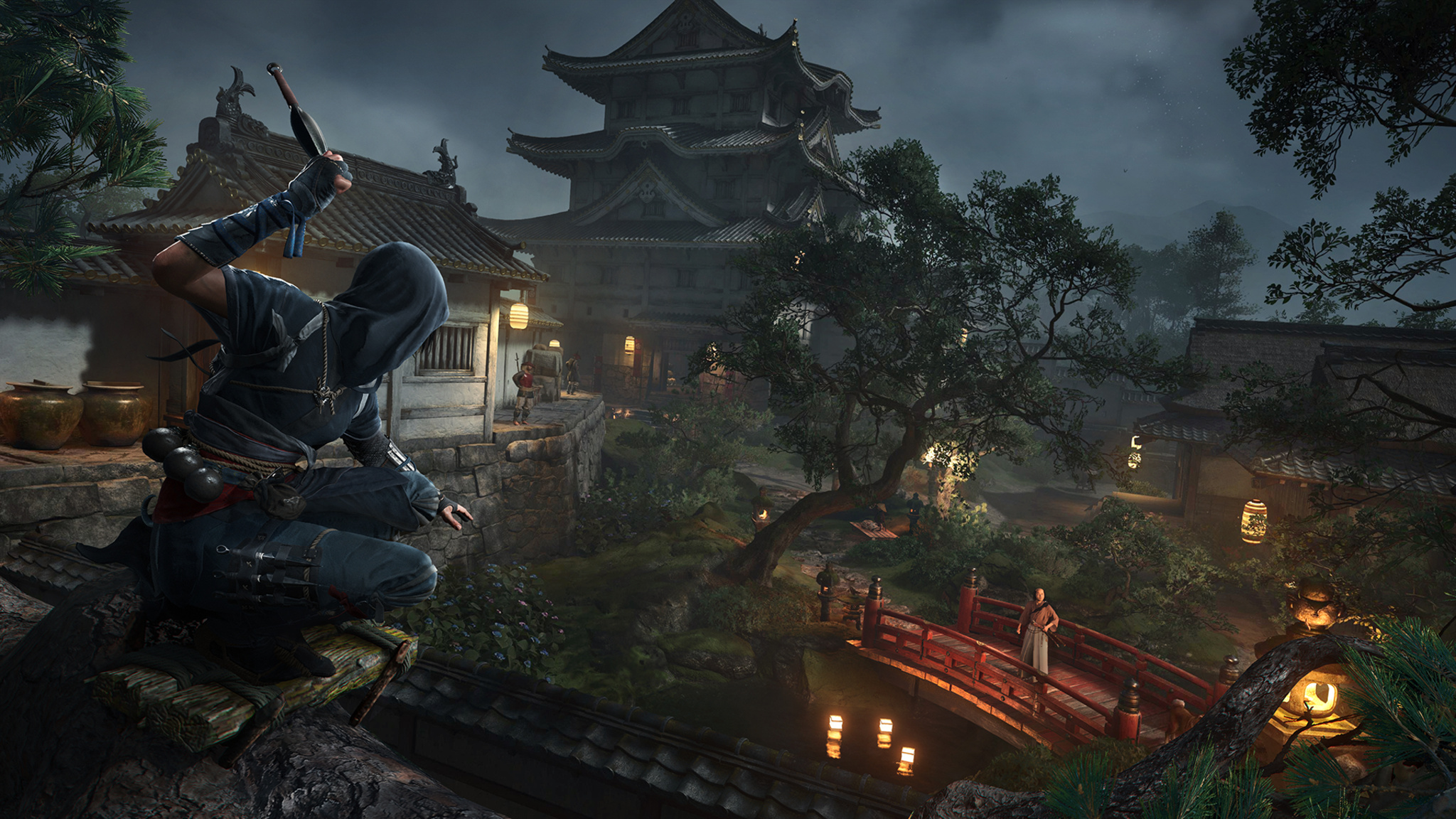 In this screenshot from Assassin’s Creed Shadows, a masked character crouches on the roof of a Japanese temple, preparing to throw a knife at an opponent who is standing on a red bridge in the background.