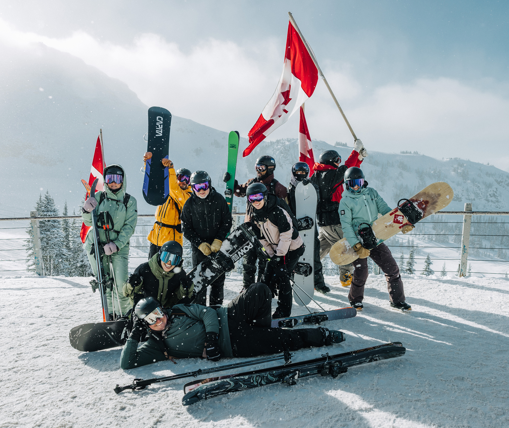 The Slopes team is gathered together in ski gear on a snowy mountain.